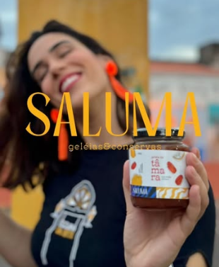 Laís Ruas sorri segurando um pote de geleia de tâmara, com o logotipo dourado SALUMA sobre a foto. Recorte provisório em baixa resolução.