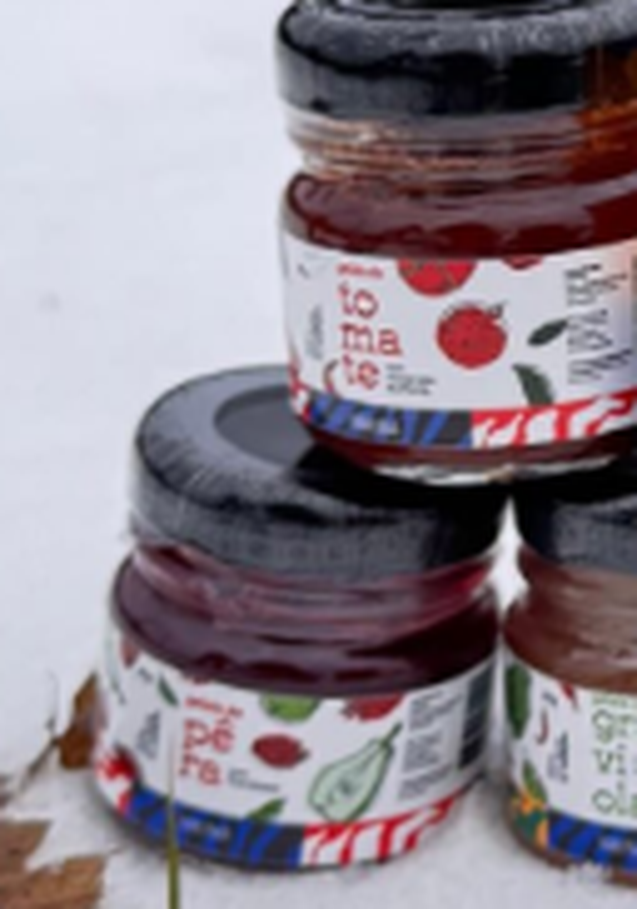 Três potes de geleia Saluma, de tomate, pera e graviola, empilhados sobre a neve